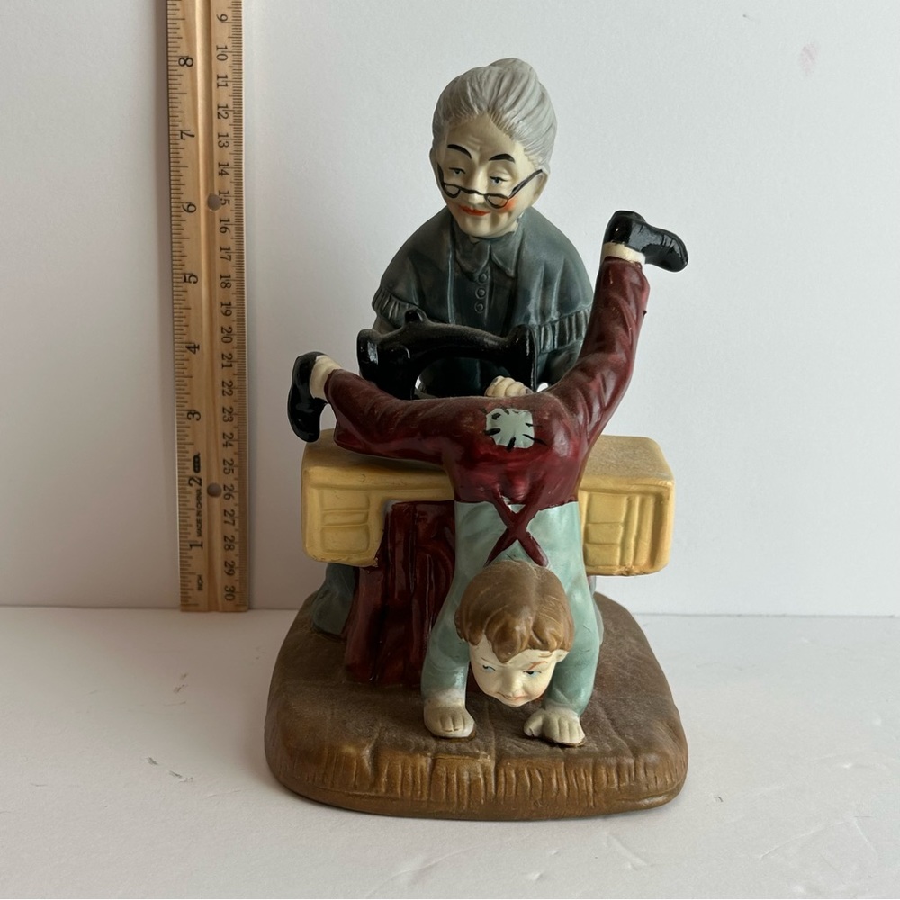 Vintage ceramic grandmother sewing pants on boy
